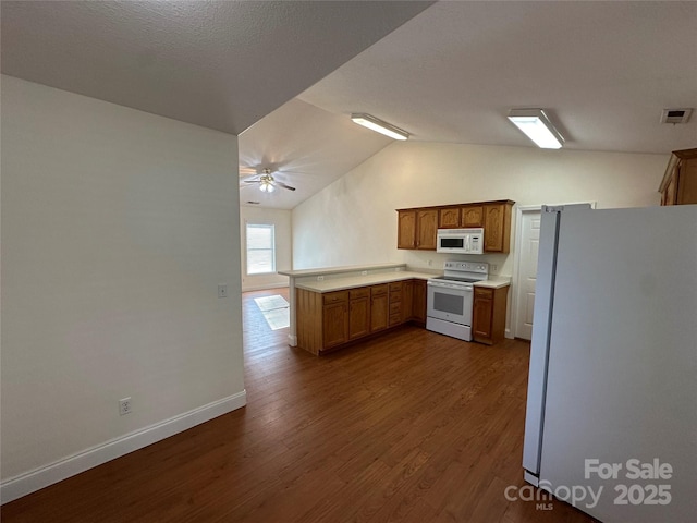 kitchen with kitchen peninsula, white appliances, dark wood-type flooring, a textured ceiling, and vaulted ceiling