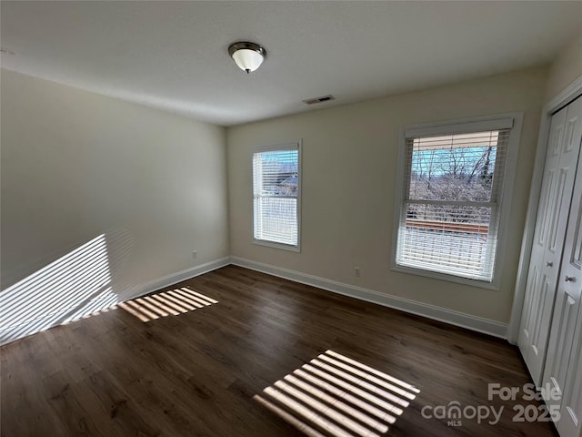 unfurnished room featuring dark wood-type flooring