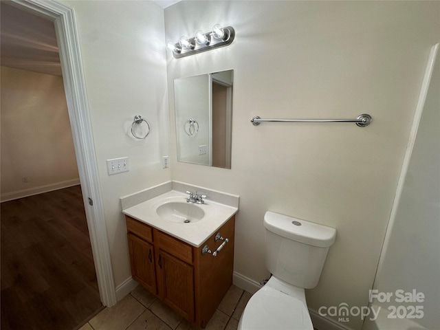 bathroom with toilet, tile patterned flooring, and vanity