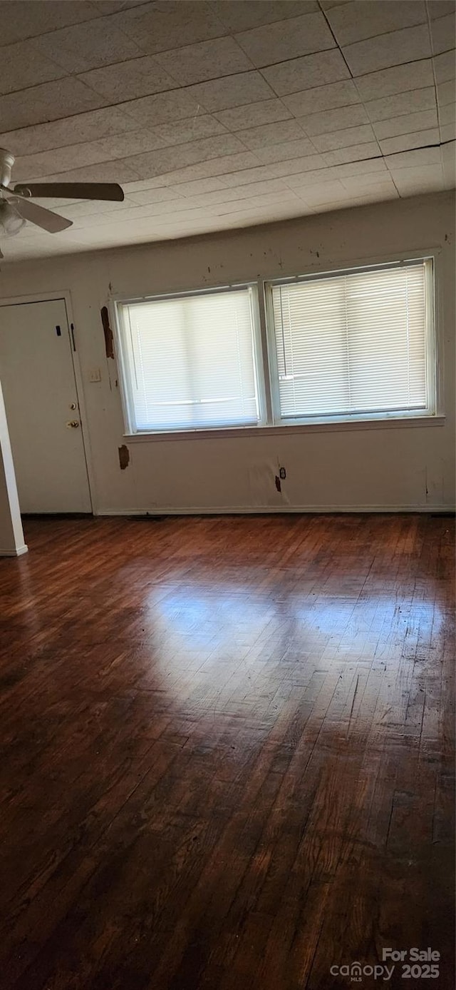 spare room with ceiling fan and dark wood-type flooring