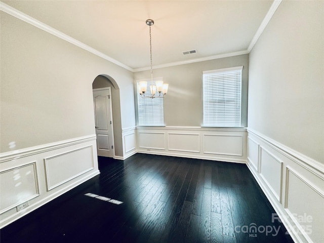 unfurnished room with a notable chandelier, crown molding, and dark hardwood / wood-style floors