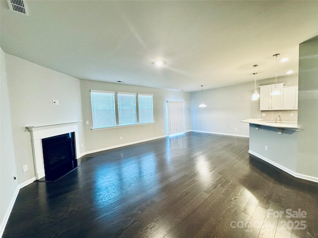 unfurnished living room with dark hardwood / wood-style floors