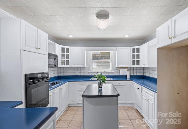 kitchen with white cabinets, black appliances, light tile patterned floors, and a kitchen island