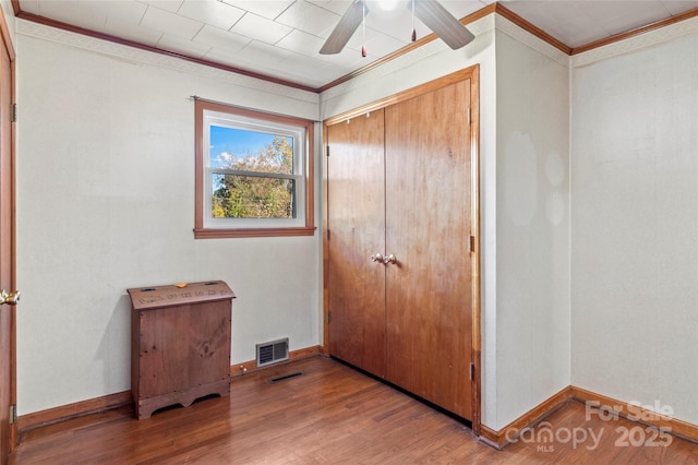 bedroom featuring a closet, ceiling fan, ornamental molding, and hardwood / wood-style flooring