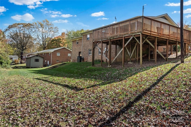 rear view of property featuring a lawn, a deck, and central AC