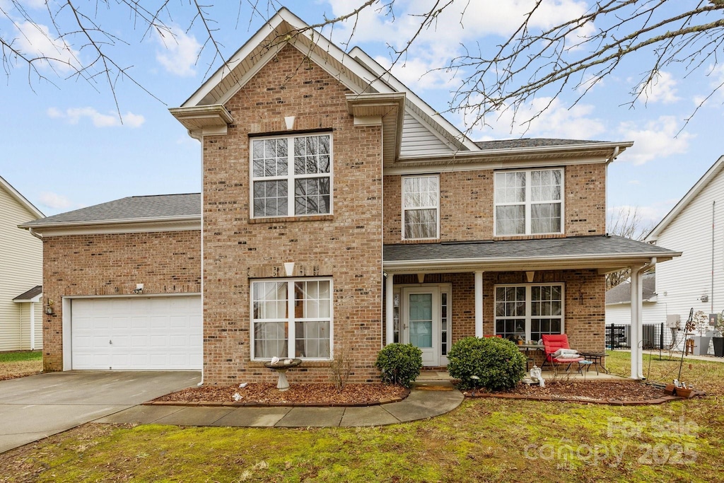 view of property featuring central AC, a garage, and a front lawn