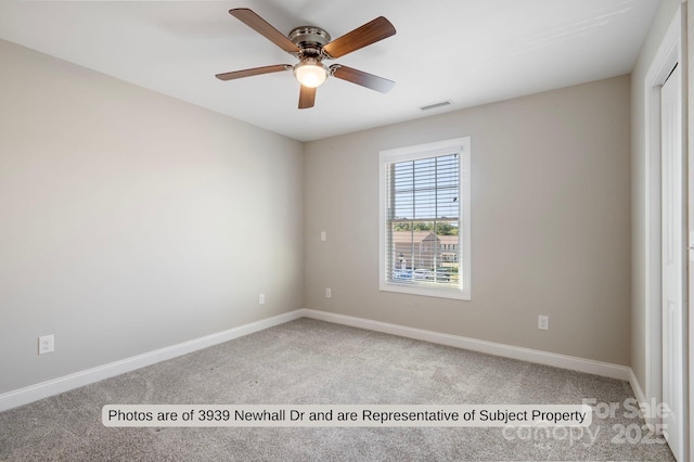 empty room featuring ceiling fan and light carpet