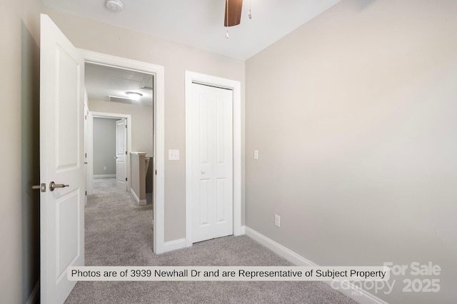 unfurnished bedroom with ceiling fan, light carpet, and a closet