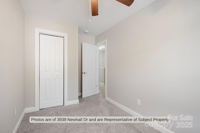 unfurnished bedroom with ceiling fan, a closet, and light carpet