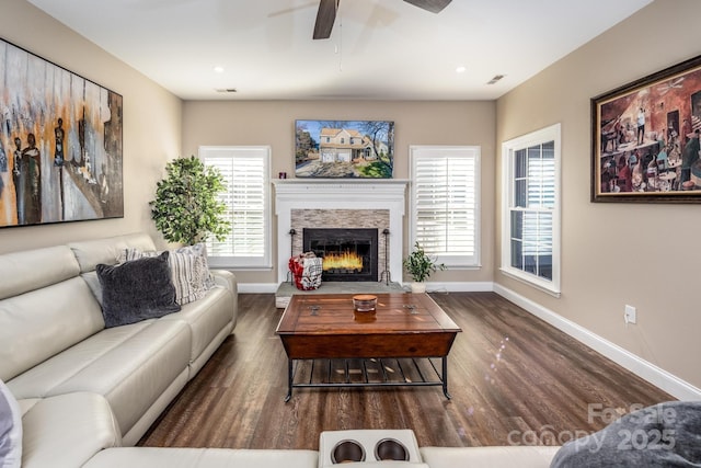 living room with ceiling fan, a fireplace, and dark hardwood / wood-style floors