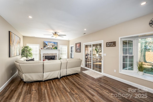 living room featuring ceiling fan and dark hardwood / wood-style flooring