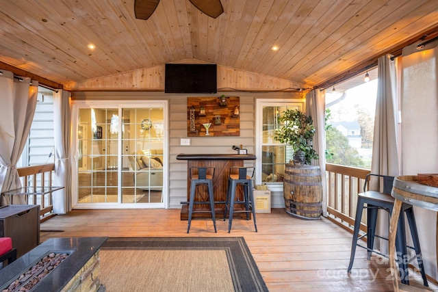 sunroom / solarium with ceiling fan, wood ceiling, and vaulted ceiling