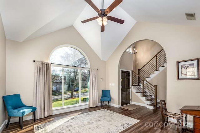 foyer entrance featuring ceiling fan with notable chandelier, dark hardwood / wood-style floors, plenty of natural light, and lofted ceiling