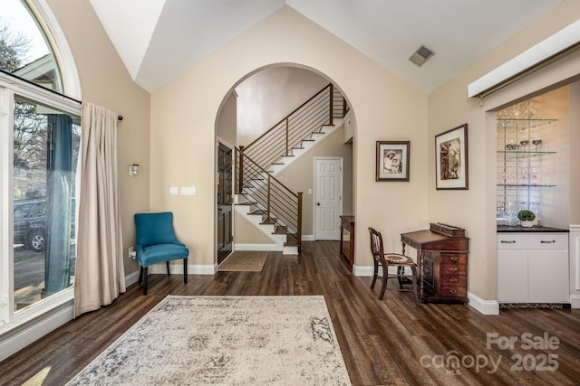 entryway with dark wood-type flooring and lofted ceiling