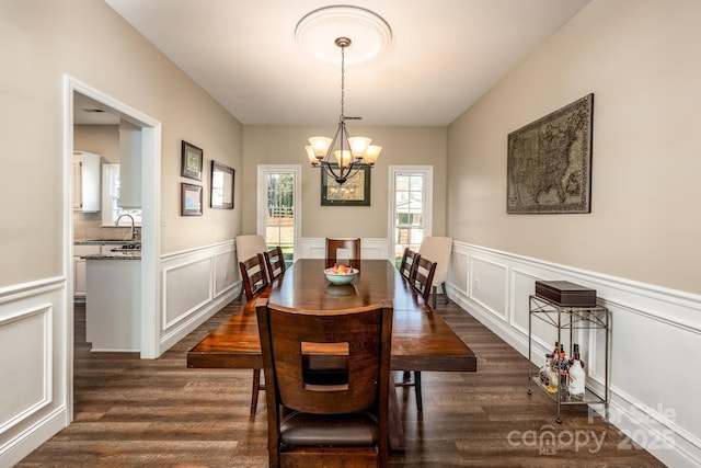 dining space with a notable chandelier, dark hardwood / wood-style floors, and sink