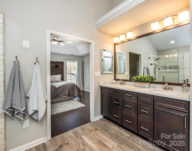 bathroom with vanity, ceiling fan, wood-type flooring, lofted ceiling, and a shower with shower door