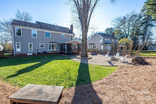 rear view of property with a fire pit, a sunroom, central air condition unit, a yard, and a patio area