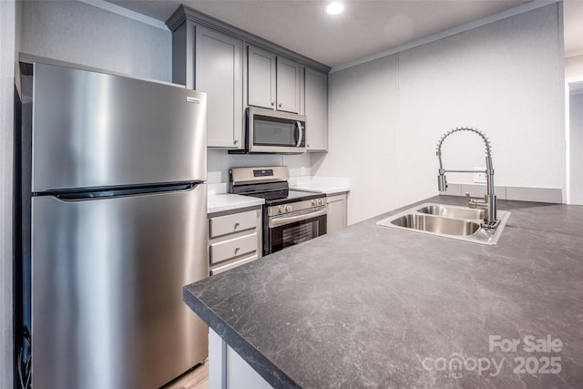 kitchen featuring gray cabinetry, sink, stainless steel appliances, and ornamental molding