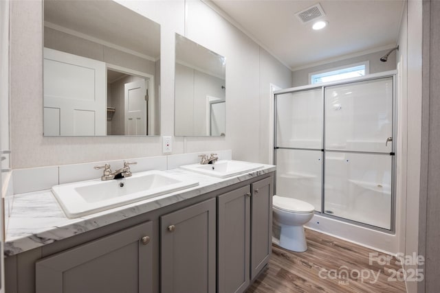 bathroom with vanity, crown molding, toilet, walk in shower, and wood-type flooring