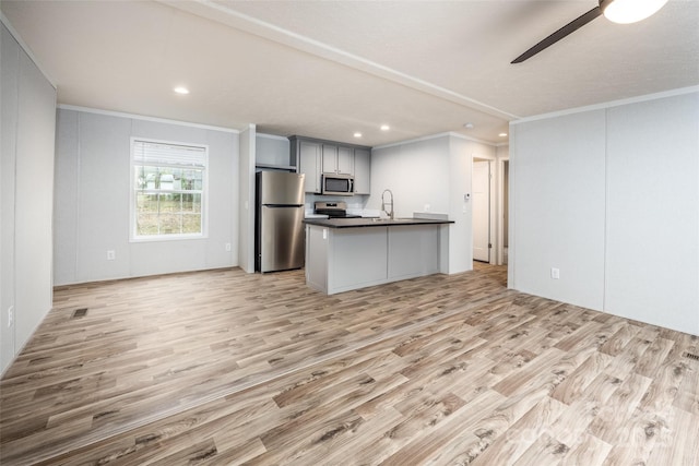 kitchen with sink, crown molding, ceiling fan, appliances with stainless steel finishes, and light hardwood / wood-style floors