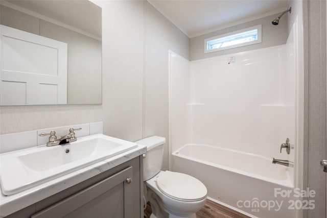 full bathroom with ornamental molding, tub / shower combination, vanity, hardwood / wood-style floors, and toilet