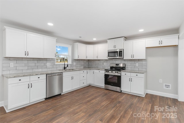 kitchen featuring dark wood-type flooring, sink, tasteful backsplash, appliances with stainless steel finishes, and white cabinets