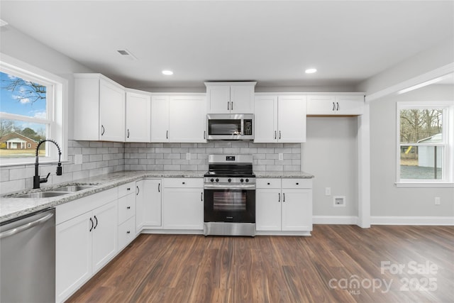 kitchen with white cabinetry, stainless steel appliances, and sink