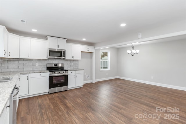 kitchen featuring tasteful backsplash, light stone counters, stainless steel appliances, and white cabinets