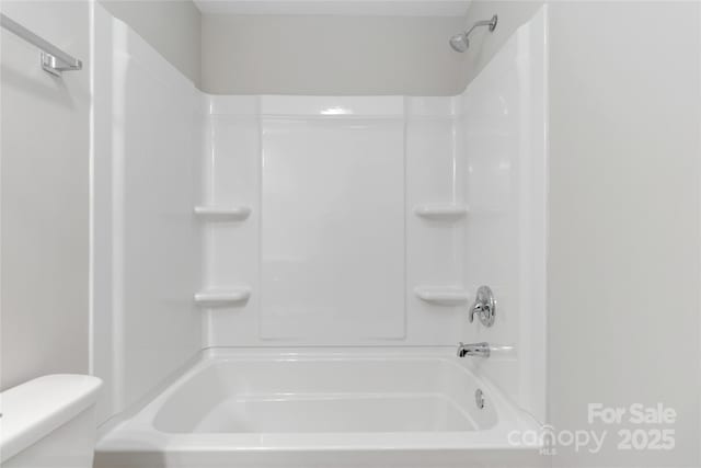 bathroom with washtub / shower combination and toilet