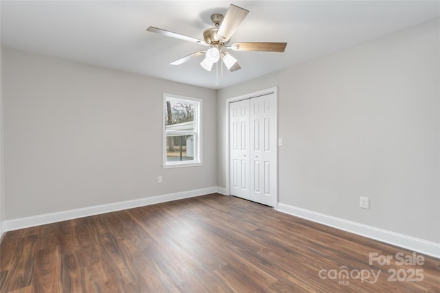 unfurnished bedroom with ceiling fan, dark hardwood / wood-style flooring, and a closet