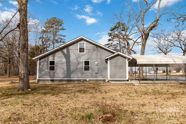 view of side of property featuring a lawn and a carport