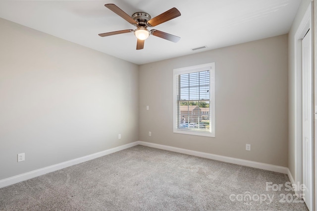 unfurnished room featuring ceiling fan and carpet