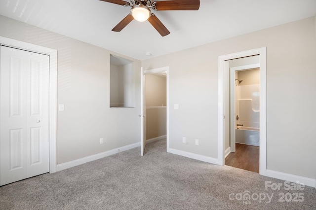 unfurnished bedroom with ensuite bath, ceiling fan, a closet, and carpet