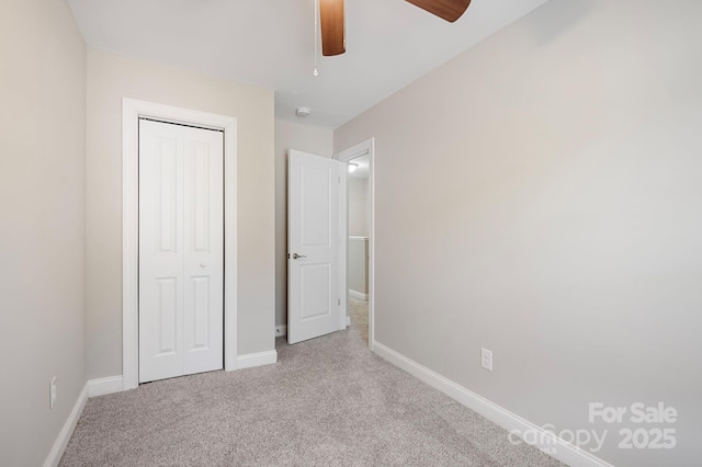 unfurnished bedroom with light carpet, a closet, and ceiling fan