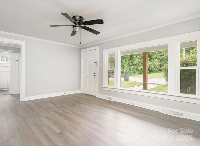 spare room featuring ceiling fan, a healthy amount of sunlight, and ornamental molding