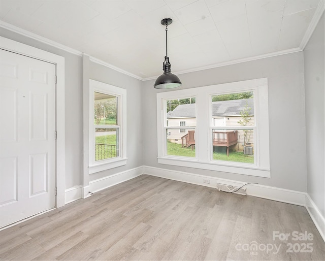 unfurnished dining area with light hardwood / wood-style floors and ornamental molding