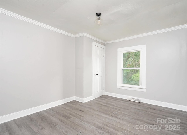 unfurnished room featuring wood-type flooring and ornamental molding