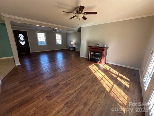 unfurnished living room featuring ceiling fan, dark hardwood / wood-style floors, and crown molding