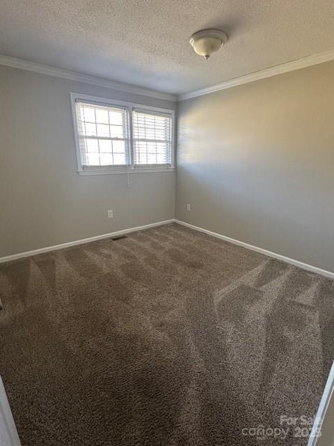 unfurnished room featuring a textured ceiling, carpet flooring, and ornamental molding