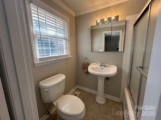 bathroom featuring toilet, ornamental molding, and enclosed tub / shower combo