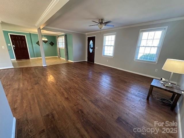 foyer entrance featuring a healthy amount of sunlight, ceiling fan with notable chandelier, and ornamental molding