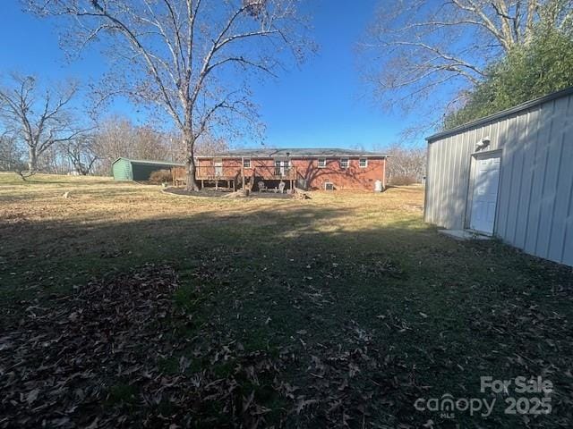 view of yard with a deck and a storage shed