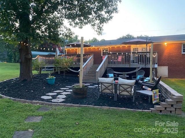 view of play area with an outdoor living space, a deck, and a yard