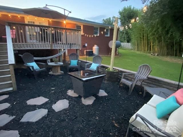 view of yard featuring a deck and an outdoor fire pit