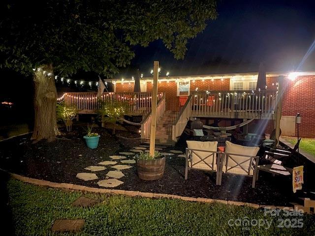 patio at twilight featuring a wooden deck