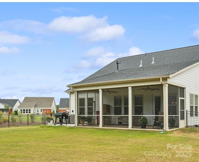 rear view of property with a sunroom, ceiling fan, a yard, and a patio