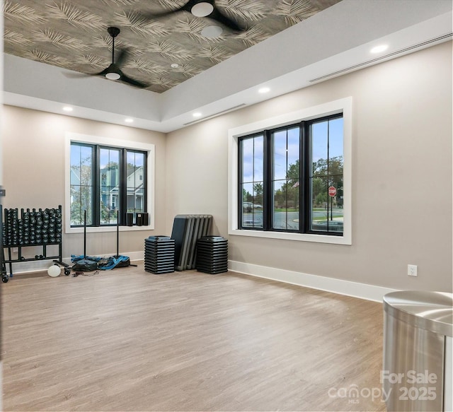 exercise area with ceiling fan and light hardwood / wood-style flooring