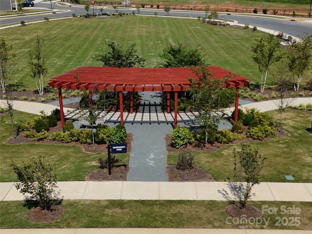 view of property's community featuring a pergola and a lawn