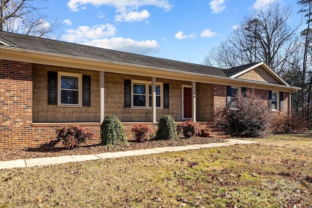 single story home with a porch and a front yard