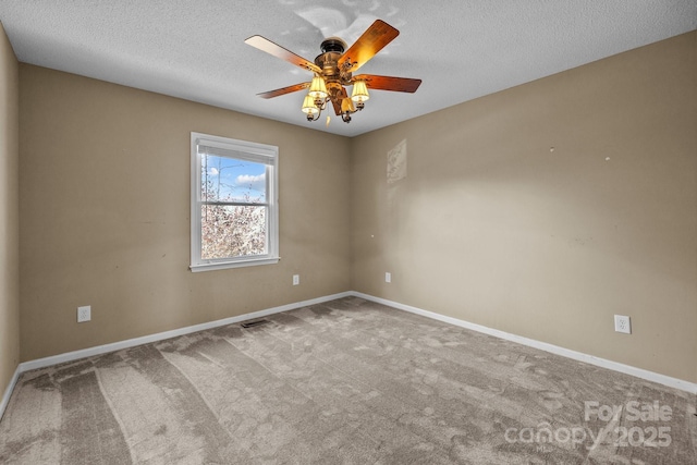 carpeted empty room featuring ceiling fan and a textured ceiling